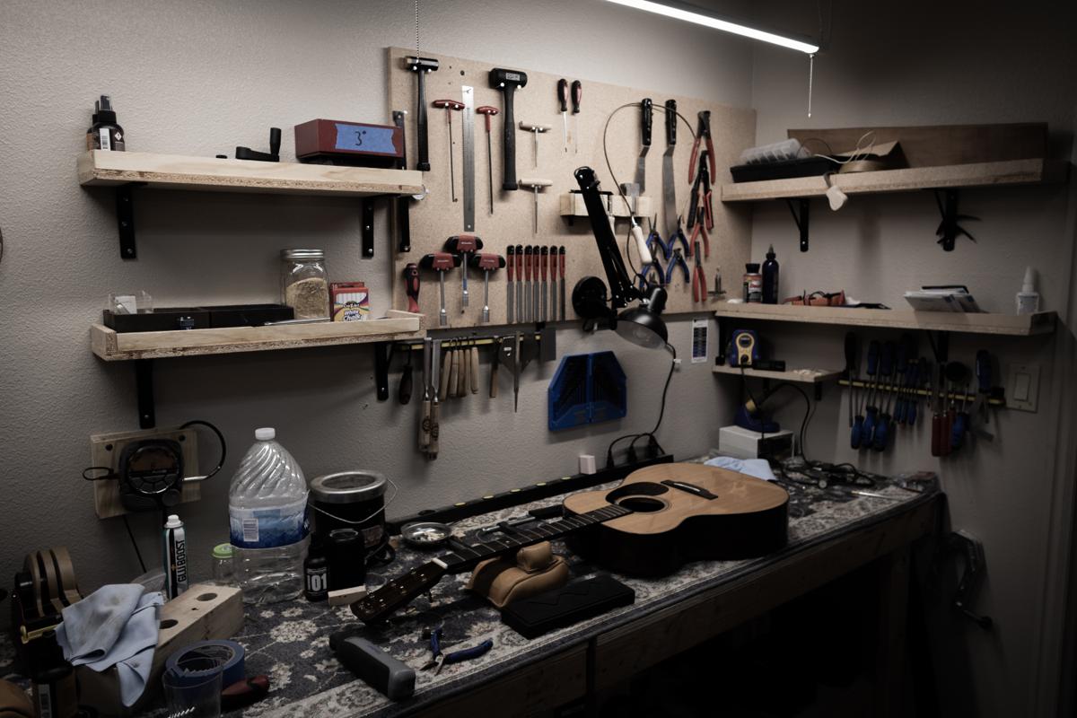 The Utah Valley Guitar Repair workbench — tools, instruments, and a day's work
