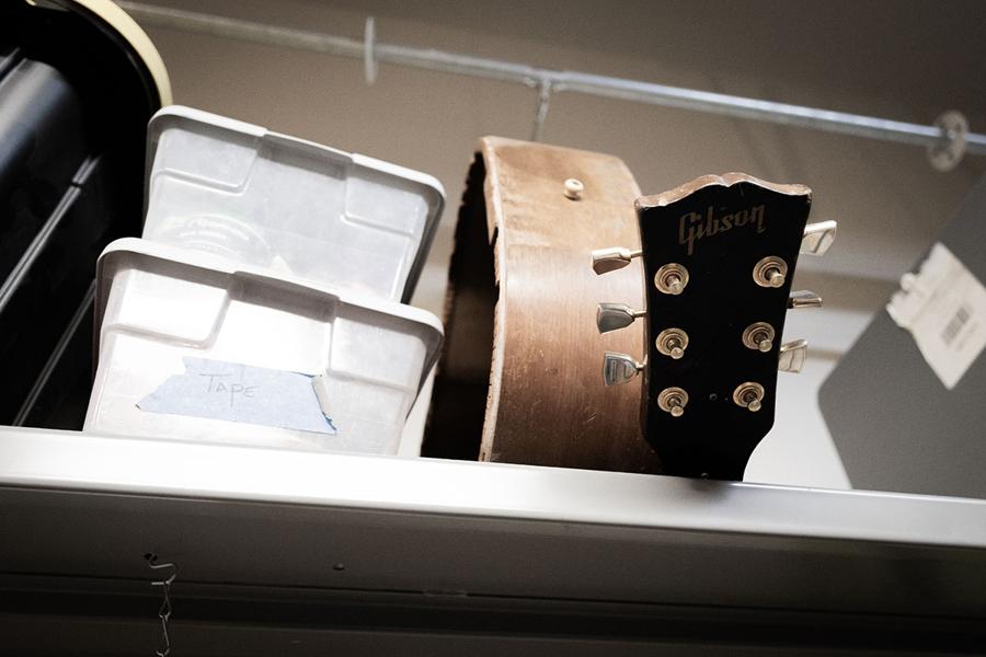 A vintage Gibson headstock resting on a shop shelf at Utah Valley Guitar Repair